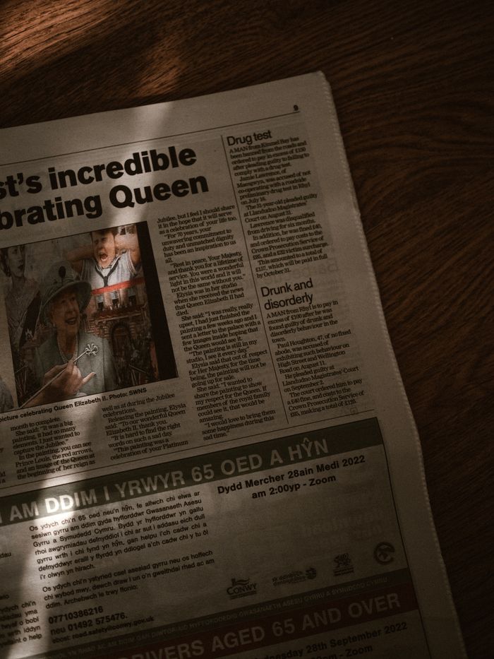 Artistic shot of a newspaper featuring editorial content with light and shadow effects.